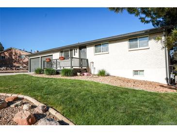 Charming single story home featuring a well-kept front yard, flowers, and a cozy front porch at 7100 Saulsbury St, Arvada, CO 80003