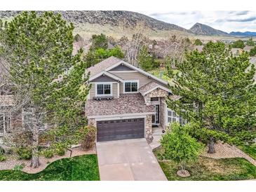 Stunning two-story home with a two-car garage, stone accents, mature trees, and mountain views at 9825 S Iris Ct, Littleton, CO 80127