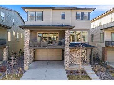 Modern two-story home boasts a stone facade, covered porch, and attached two-car garage at 15624 W Floyd Dr, Morrison, CO 80465