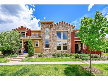 Attractive multi-story home boasts stone and stucco exterior, manicured lawn, and beautiful landscaping at 9538 Pendio Ct, Highlands Ranch, CO 80126