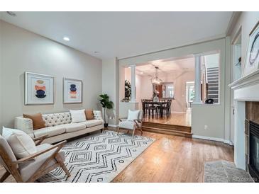 Bright living room with hardwood floors, fireplace, and an open floor plan to the dining area at 222 S Monroe St, Denver, CO 80209