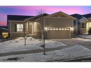 Attractive ranch home with a two-car garage and snow-covered landscaping at 22046 E Allenspark Pl, Aurora, CO 80016