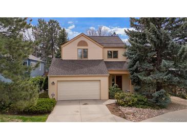 Charming two-story home featuring a two-car garage, neutral paint, and mature trees in a well-maintained yard at 851 Racquet Ln, Boulder, CO 80303