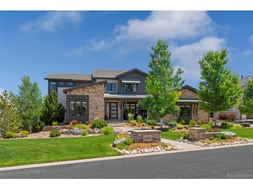 Stunning home featuring a stone and siding exterior, beautifully landscaped yard, and well-maintained lawn at 10826 Evergold Way, Highlands Ranch, CO 80126
