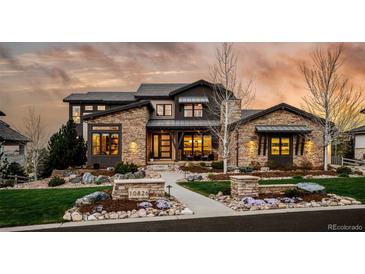 Stunning stone-clad home featuring a professionally landscaped front yard and charming walkway at 10826 Evergold Way, Highlands Ranch, CO 80126