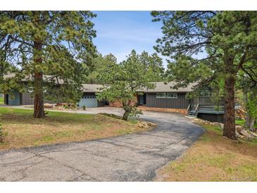 Charming ranch-style home with mature trees, spacious driveway, and inviting entryway at 21859 Grandview Ave, Golden, CO 80401