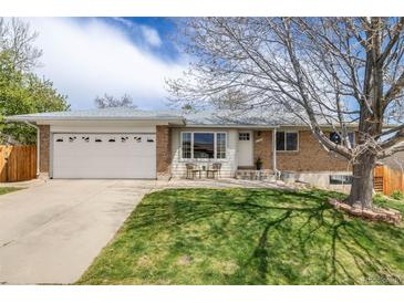 Charming ranch-style home featuring a well-manicured lawn, brick accents, and an attached two-car garage at 13367 W Montana Pl, Lakewood, CO 80228