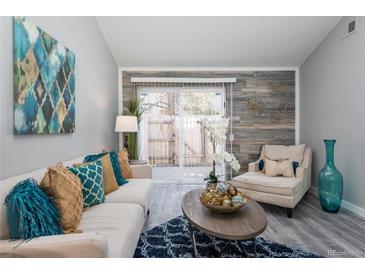 Bright living room with comfy seating, stylish decor, and access to a private patio at 14396 E Florida Ave # B, Aurora, CO 80012