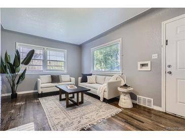 Bright living room features hardwood floors, neutral walls, and stylish, comfortable seating at 1388 Kenton, Aurora, CO 80010