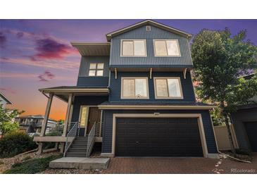 Two-story home featuring a black garage door, blue siding and covered front porch at 20031 Elgin Dr, Denver, CO 80249