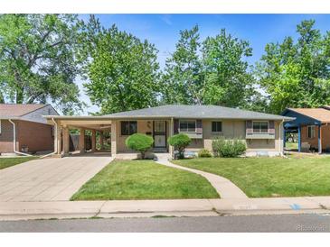 Charming brick home with a well-manicured lawn, covered parking, and mature trees at 1637 S Stuart St, Denver, CO 80219