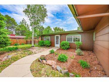 Charming single-story home boasts a welcoming front yard with mature trees and a stone walkway to the front door at 5722 W Chestnut Ave, Littleton, CO 80128
