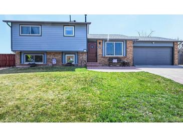 Inviting two-story home with a well-maintained lawn and brick accents, offering great curb appeal at 6376 S Estes St, Littleton, CO 80123