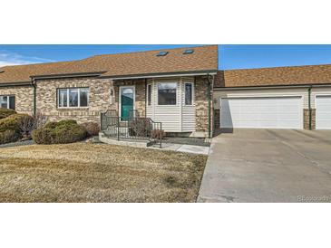 Charming single-story home with brick and siding and a well-maintained front yard and an attached one car garage at 2585 E Egbert St, Brighton, CO 80601