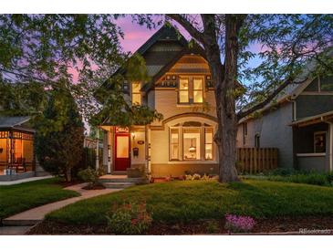 Charming two-story home with a red door, lush lawn, and mature trees at 848 S Emerson St, Denver, CO 80209