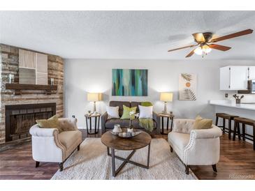 Inviting living room with stone fireplace, ceiling fan, and neutral decor at 1239 S Flower Cir # C, Lakewood, CO 80232