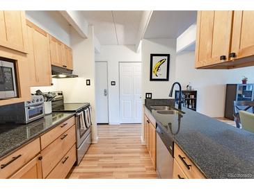 Bright kitchen featuring granite counters, stainless appliances, and wood cabinets at 777 N Washington St # 508, Denver, CO 80203
