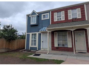 Two-story townhouse featuring blue and red siding, white trim, and a small front lawn at 15703 E 13Th Pl, Aurora, CO 80011