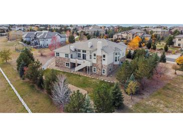 Expansive backyard on a two-story house with stone accents and lush landscaping in a desirable community at 6425 Tremolite Dr, Castle Rock, CO 80108