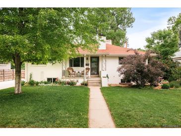 Charming, white-painted home with a red roof, covered porch and meticulous landscaping at 5885 S Huron St, Littleton, CO 80120