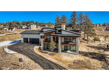 Modern home with 3-car garage, situated on a hillside lot with mountain views at 5820 Powell Rd, Parker, CO 80134