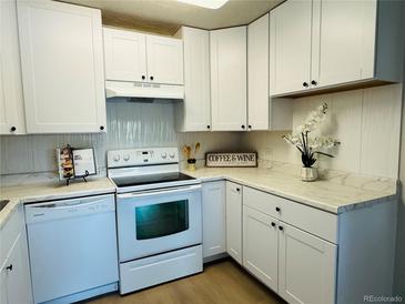 Bright kitchen featuring white cabinetry, sleek appliances, and light countertops at 755 S Alton Way # 12C, Denver, CO 80247