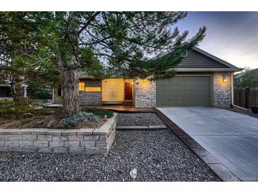Charming front exterior with brick, modern curb appeal, mature landscaping, and an attached garage at 5461 S Youngfield Ct, Littleton, CO 80127