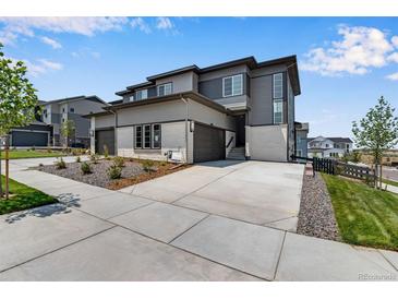 Modern townhome showcasing a gray exterior, private driveway, and well-maintained landscaping at 6881 Oak Canyon Cir, Castle Pines, CO 80108