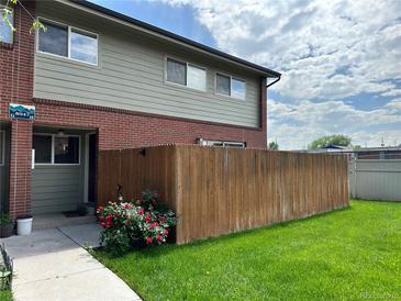 Charming townhouse with brick accents, a well-kept lawn, and a privacy fence, perfect for outdoor enjoyment at 8047 Wolff St # H, Westminster, CO 80031
