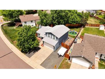 Inviting home featuring a fenced backyard and a spacious two-car garage with a lengthy driveway at 8977 W Toller Ave, Littleton, CO 80128