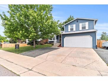 Charming two-story home with a well-manicured lawn, mature trees, and an attached two-car garage at 8977 W Toller Ave, Littleton, CO 80128