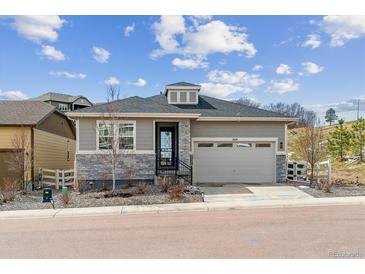 Charming single-Gathering home with grey siding, stone accents, and a two-car garage at 1610 Cade Ave, Castle Rock, CO 80104