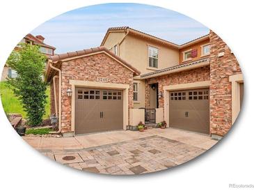 Beautiful home exterior featuring brick accents, a two-car garage, and well-maintained landscaping at 9246 Sori Ln, Highlands Ranch, CO 80126