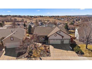 Charming home with a three car garage and a well-maintained lawn, nestled in a quiet neighborhood at 21142 Hawthorne Ln, Parker, CO 80138