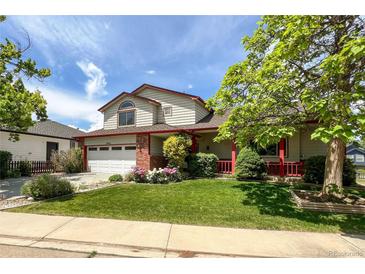 Charming two-story home with a well-manicured lawn, mature trees, and a cozy front porch at 2912 Lake Park Way, Longmont, CO 80503