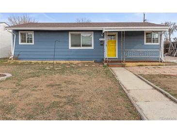 Charming single-story home featuring a blue exterior, a bright yellow front door, and a covered front porch at 4211 E 69Th Ave, Commerce City, CO 80022