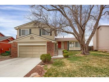 Charming two-story home featuring neutral siding, brick accents, an attached garage, and a well-manicured lawn at 8441 Timberwood St, Littleton, CO 80126
