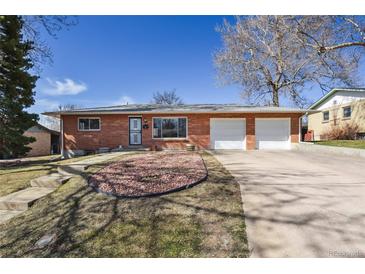 Charming brick home featuring a two-car garage, mature trees, and a landscaped front yard at 2813 S Zenobia St, Denver, CO 80236