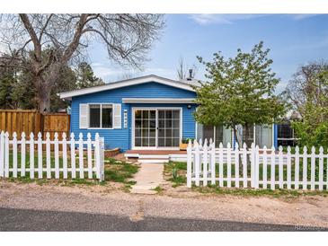 Charming blue home features a white picket fence and inviting front yard at 6445 Second St, Louviers, CO 80131