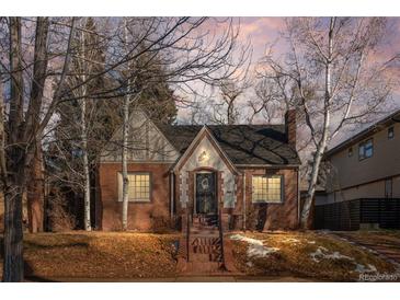 Brick home with a charming front porch and landscaping at 2068 Jasmine St, Denver, CO 80207