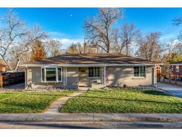 Charming ranch home featuring a well-manicured lawn and walkway leading to the front door at 5500 Holland Dr, Arvada, CO 80002