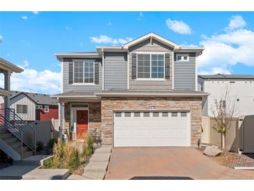 Beautiful two-story home with a stone facade, gray siding and well manicured lawn at 4419 N Quatar Ct, Aurora, CO 80019
