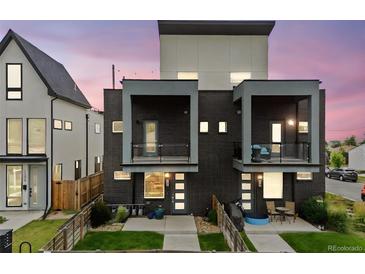 Modern home featuring a stylish brick facade, balconies, and well-maintained front yard with a privacy fence at 1302 N Stuart St, Denver, CO 80204