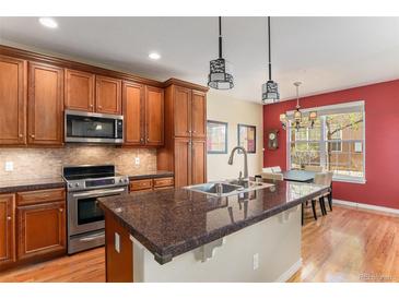 Modern kitchen features stainless steel appliances, granite countertops, and custom cabinets at 11962 W Long Cir # 103, Littleton, CO 80127