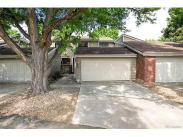 Inviting townhouse featuring an attached two-car garage, well-maintained landscaping, and a charming entryway at 7925 W Layton Ave # 605, Littleton, CO 80123