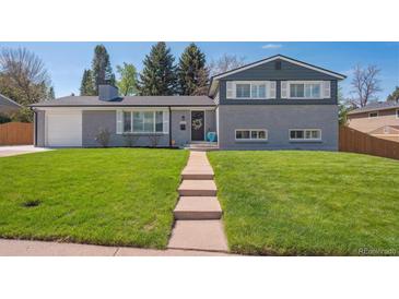 Beautiful two-story home features a brick facade, well-manicured lawn, and inviting front entrance at 8242 E Briarwood Pl, Centennial, CO 80112