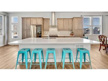 Bright, modern kitchen with large island, stainless steel appliances, and a tiled backsplash at 4863 River Landing Ave, Firestone, CO 80504