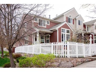 Charming multi-story home with a white picket fence and beautiful landscaping, perfect for families at 661 Snowberry St, Longmont, CO 80503