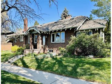 Charming brick home with a well-manicured lawn and inviting front porch at 2601 N Clayton St, Denver, CO 80205
