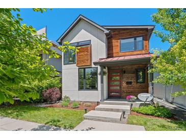 Modern two-story home featuring a red front door and a mix of white siding and stained wood accents at 3425 W Moncrieff Pl, Denver, CO 80211